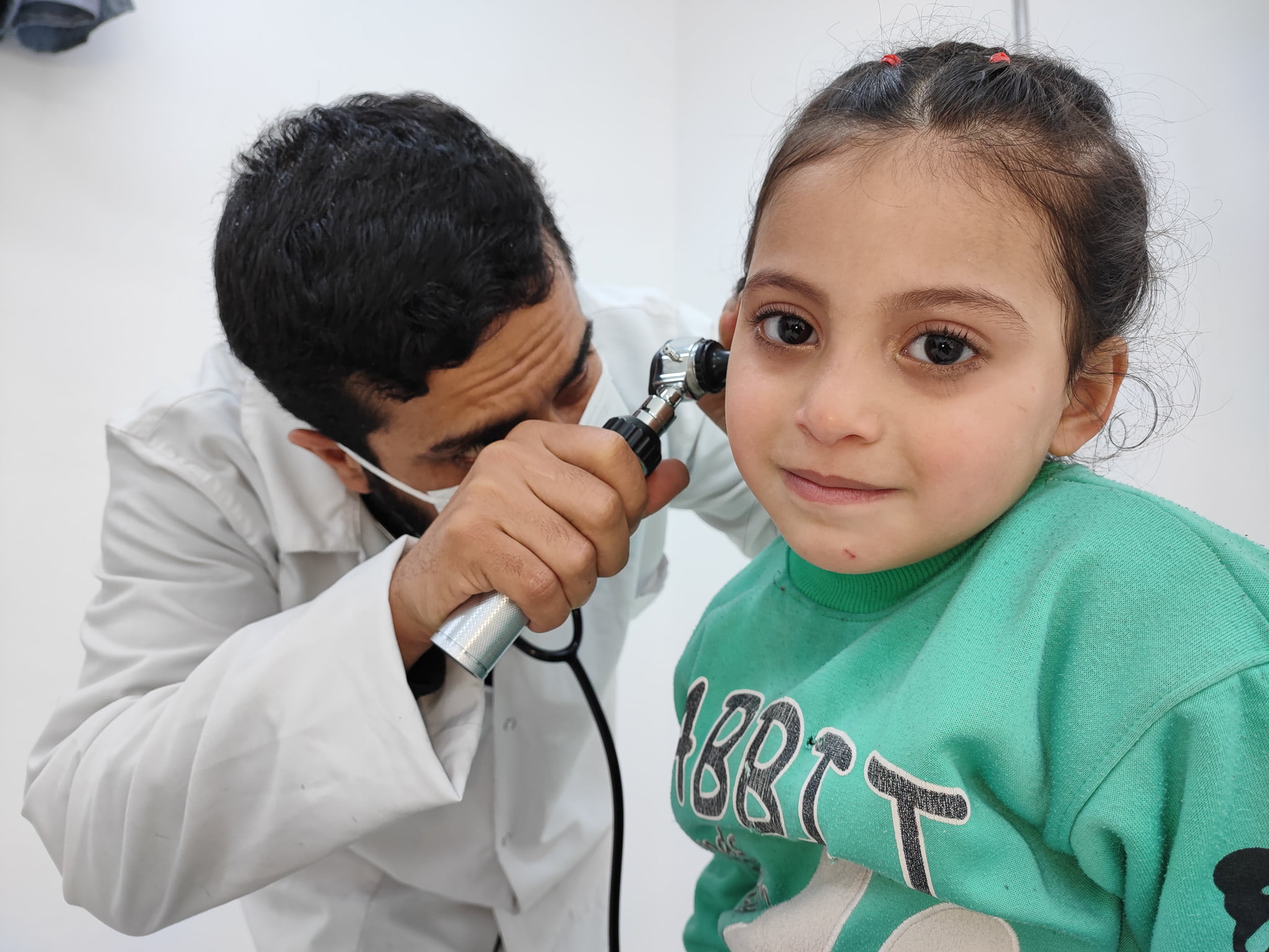 A doctor treats a child in a temporary shelter